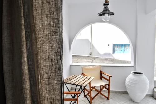 a room with a chair and a table and a window at Casa Valeri Ι in Naxos Chora