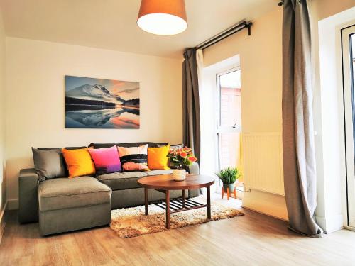 a living room with a couch and a table at Lovely Holiday Home in Birmingham City Center 3 Bedrooms House By HF Group in Birmingham