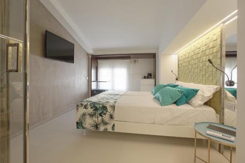 a bedroom with a large bed and a television at Hedoné Design Experience B&B in Agrigento