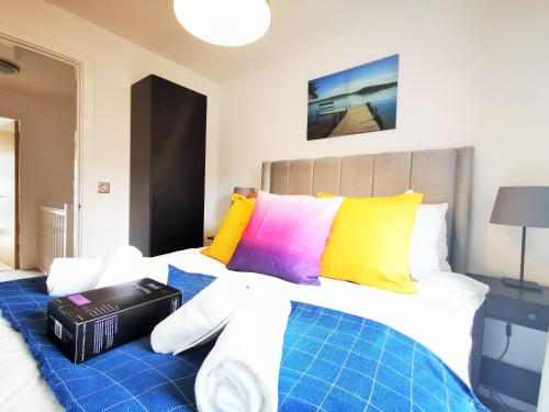 une chambre avec un grand lit avec des oreillers colorés dans l'établissement Lovely Holiday Home in Birmingham City Center 3 Bedrooms House By HF Group, à Birmingham