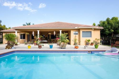 uma casa com piscina em frente a uma casa em Yuli's Home em Miami