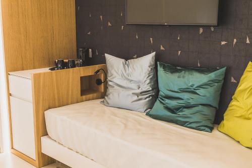 a bed with two pillows on top of it at Hedoné Design Experience B&B in Agrigento