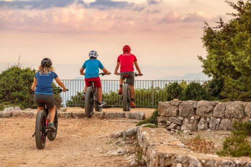 three people riding bikes down a dirt road at bedbike Baunei in Baunei