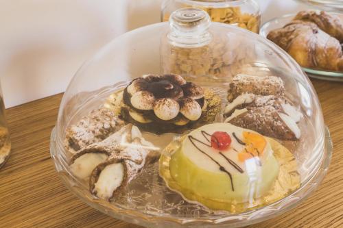 a glass plate filled with different types of pastries at Hedoné Design Experience B&B in Agrigento