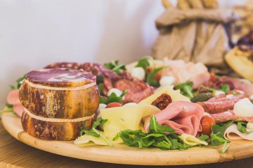 a plate of food with meat and cheese on a table at Hedoné Design Experience B&B in Agrigento