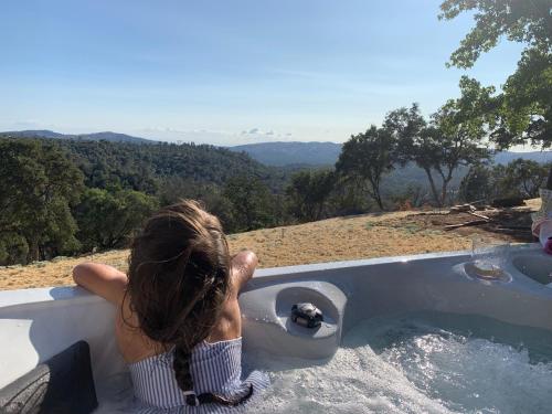 a woman in a bath tub with her feet in the water at Moon Ranch - a gateway to Yosemite in Mariposa