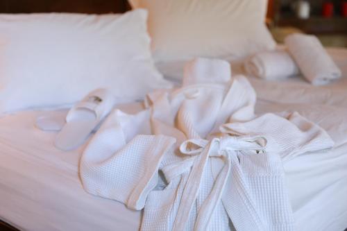 a white bed with white towels on top of it at Boutique Hotel Palea Poli in Naousa Imathias