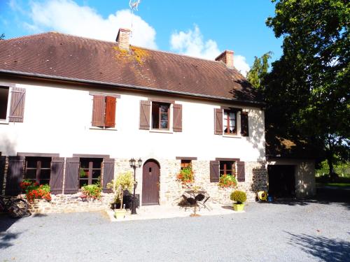 une maison blanche avec un toit marron dans l'établissement La guesnonniere, à Quibou