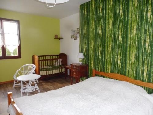 een slaapkamer met een bed en een groen gordijn bij La guesnonniere in Quibou