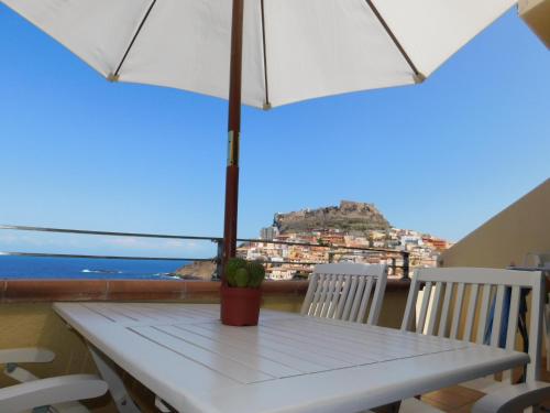 a white table with chairs and an umbrella at Il doppio nodo in Castelsardo