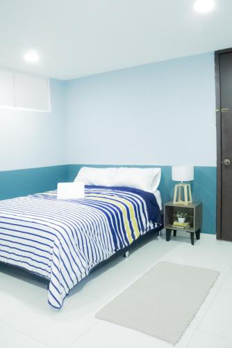 a bedroom with a bed with a blue wall at Privada de Horacio 18 Residences in Mexico City