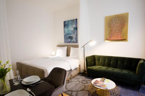 ein Hotelzimmer mit einem Bett und einem Sofa in der Unterkunft Studio Apartments Naschmarkt - Mai's Apartments - Naschmarkt by Arbio in Wien