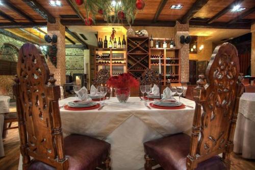 stół jadalny z krzesłami i butelkami wina w obiekcie Boutique Hotel Palea Poli w mieście Nausa