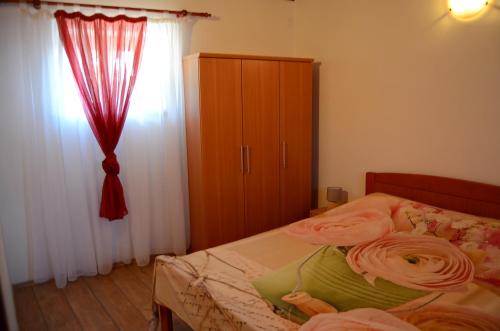 a bedroom with a bed and a dresser and a window at Apartment Duerose in Buje