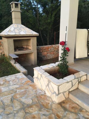 a stone fireplace in a yard with a stone patio at Villa Marko in Kras