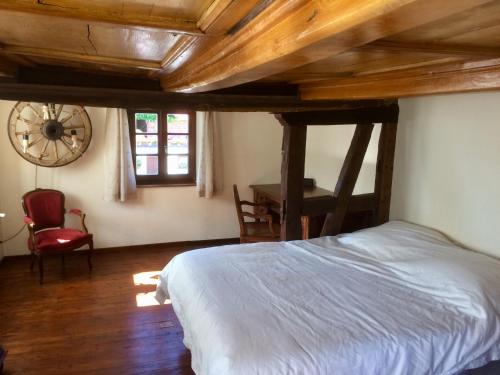 a bedroom with a bed and a wooden ceiling at Gîte Les Chotzi's in Maennolsheim