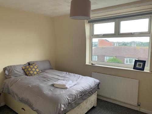 a small bed in a room with a window at Nice double and single rooms in the quiet area with excellent shared facilities in Plymouth