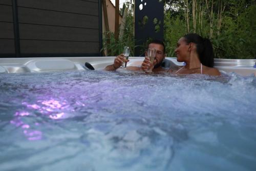 a man and a woman sitting in a hot tub at CasaCosy in Les Michels