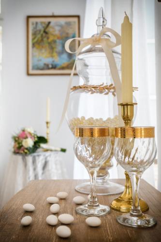 two wine glasses and a candle on a table at Evagelia's deluxe villa-Roof Top Jacuzzi in Skopelos Town