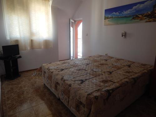 a bedroom with a bed in a room with a window at Dunav Apt.2 in Ravda