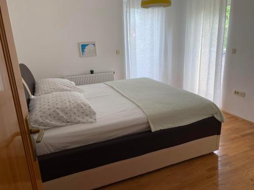 a bed with white sheets and pillows in a bedroom at Ferienhaus in Široki Brijeg