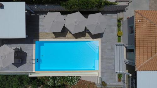 an overhead view of a blue swimming pool with umbrellas at Drimonari Villas in Agios Nikitas