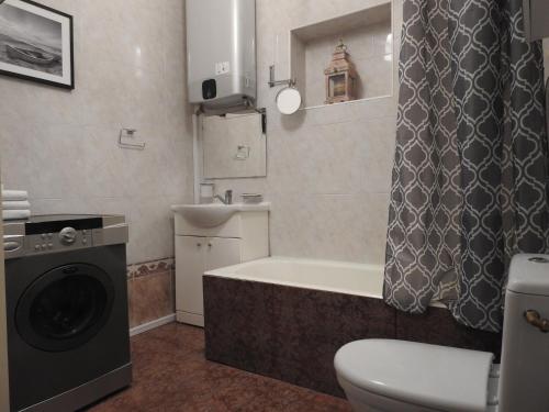 een badkamer met een wasmachine en een bad bij Laisvės alėja in Kaunas
