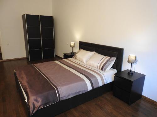 een slaapkamer met een groot bed met 2 nachtkastjes bij Laisvės alėja in Kaunas
