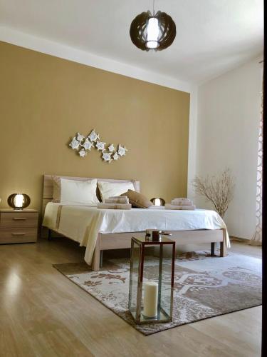a bedroom with a large bed and a table at Montellinos Suite Tortora in SantʼAntìoco