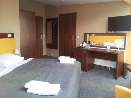 ein Hotelzimmer mit einem Bett mit zwei Handtüchern darauf in der Unterkunft Willa Plażowa in Misdroy