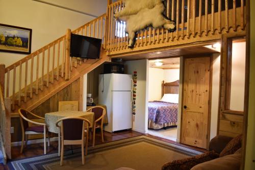 a living room with a staircase and a room with a bed at Exit Glacier Lodge in Seward