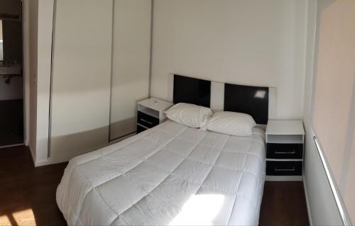 - une chambre avec un lit blanc et 2 tables de chevet dans l'établissement Tu lugar en Villa, à Villa Constitución
