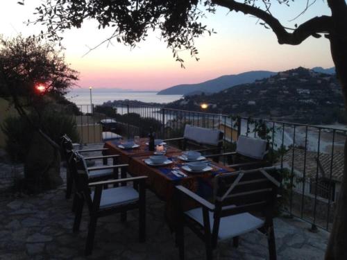 a wooden table with chairs and a view of the ocean at Villa Rosa in Torre delle Stelle