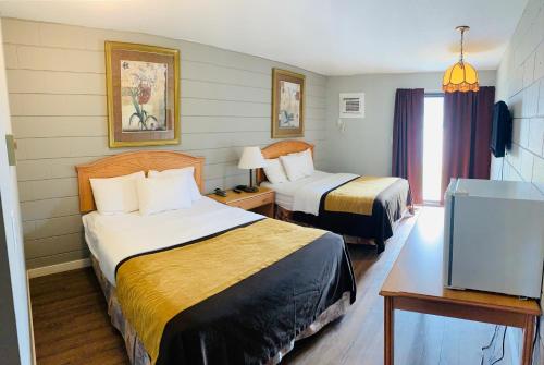 pokój hotelowy z dwoma łóżkami i telewizorem w obiekcie Armstrong Inn w mieście Armstrong