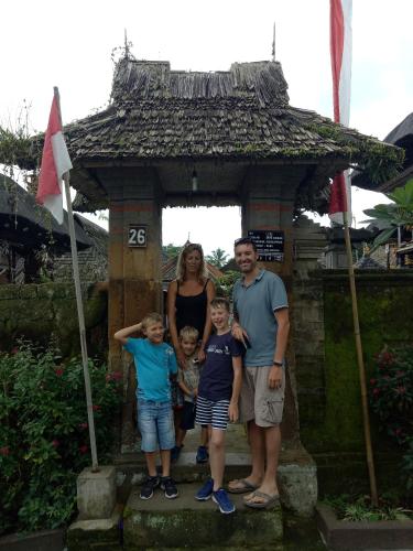 a family standing in front of a small gate at Pier26 Bali Homestay in Nusa Dua