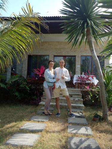 a man and woman standing in front of a house at Pier26 Bali Homestay in Nusa Dua