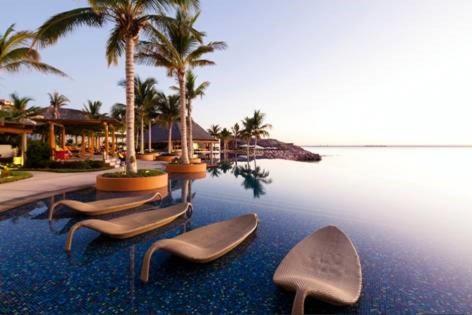 a group of chairs sitting in the water at a resort at Casa Tu Paz in La Paz