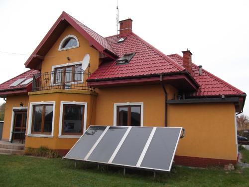a house with a solar panel in front of it at Dworek w Zieleni in Warsaw