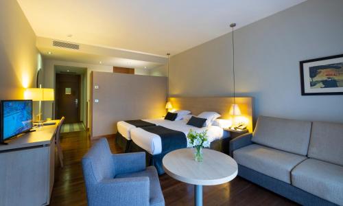 a hotel room with a bed and a couch at Hotel Spa Attica21 Vilalba in Villalba