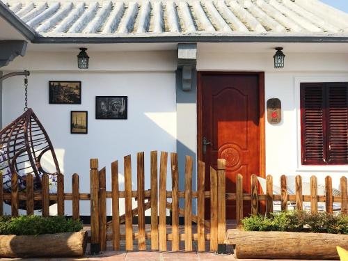 a house with a wooden fence and a wooden door at Mumian inn in Chaozhou