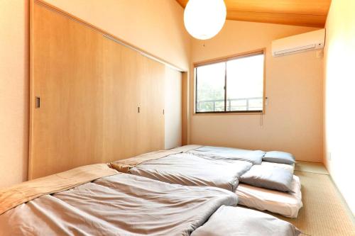 a room with four beds in it with a window at YADOYA Asakusa-Honkan in Tokyo