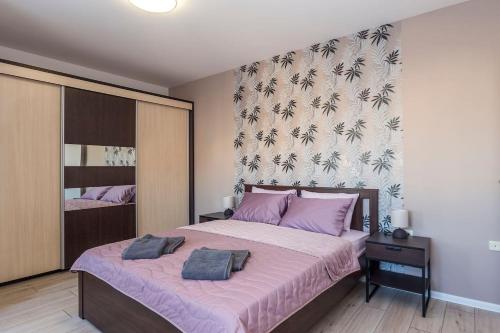 a bedroom with a large bed with purple pillows at Stunning location and views!Foothills of Old town! in Plovdiv
