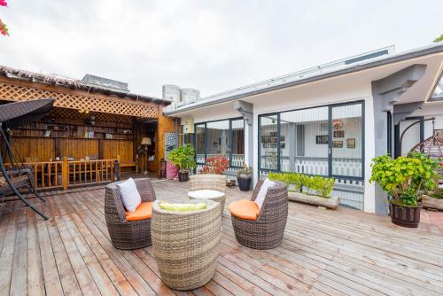 a patio with wicker chairs and tables on a wooden deck at Mumian inn in Chaozhou
