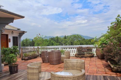 a patio with wicker chairs and a table and a fence at Mumian inn in Chaozhou