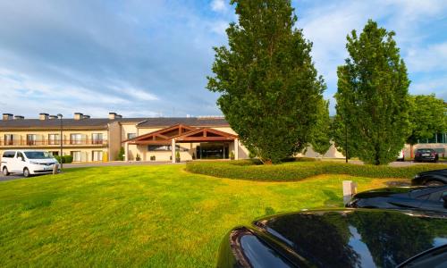 a car parked in front of a building with trees at Hotel Spa Attica21 Vilalba in Villalba