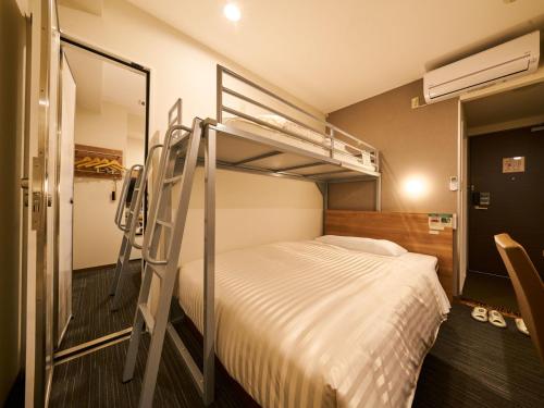 a bedroom with two bunk beds and a ladder at Super Hotel Mihara Ekimae in Mihara