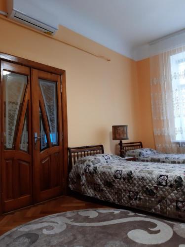 1 dormitorio con 2 camas y ventana en Apartment Orgelsaal en Chernivtsi