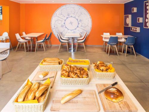 a table with baskets of bread and pastries on it at Ibis Styles La Louvière in La Louvière