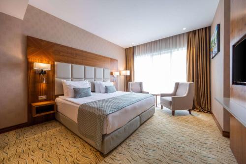a hotel room with a large bed and a window at Clarion Hotel Istanbul Mahmutbey in Istanbul