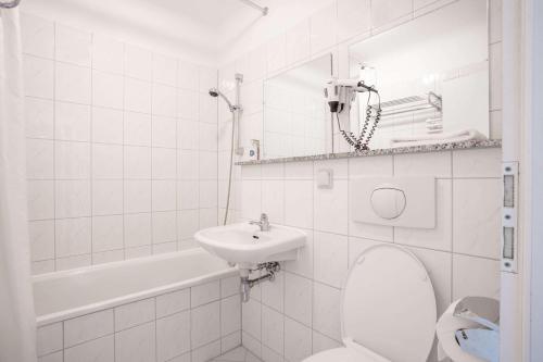 Baño blanco con aseo y lavamanos en Soibelmanns Hotel Weimar, en Weimar
